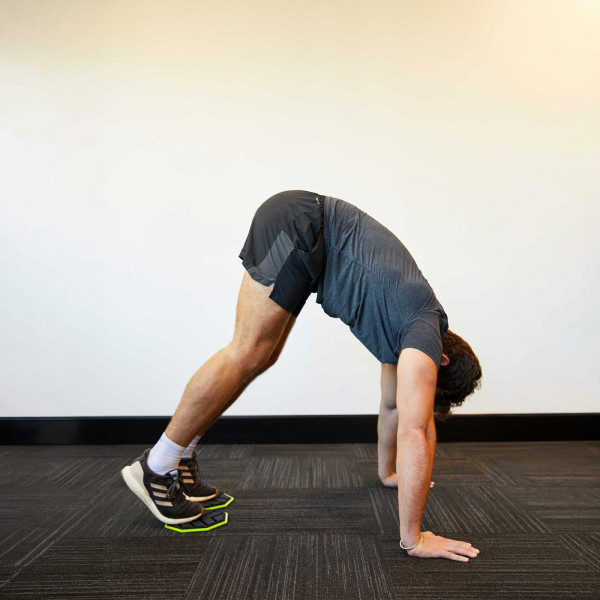 Model using the PTP Core Sliders for a pike exercise in a plank position.
