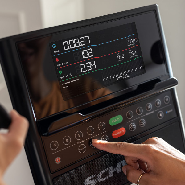 Model adjusting the incline setting on the Schwinn 590E Elliptical console