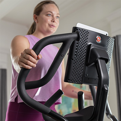 Model gripping the moving handlebars on the Schwinn 590E Elliptical