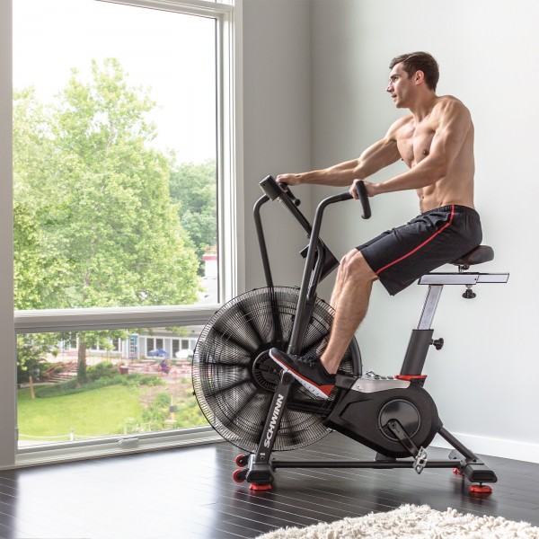The Schwinn Airdyne AD8 Airbike configured as a bike ergometer, focusing on the user's engagement and the bike's functionality in a home fitness setting