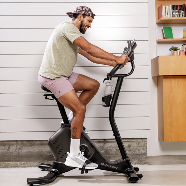 An exerciser using the Schwinn 590U Upright Bike focused on their workout, exemplifying a user engaging with the product