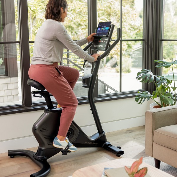 The Schwinn 590U Upright Bike set up in a home environment, illustrating its compact size and suitability for home use