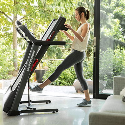 User folding the Schwinn 510T treadmill for storage