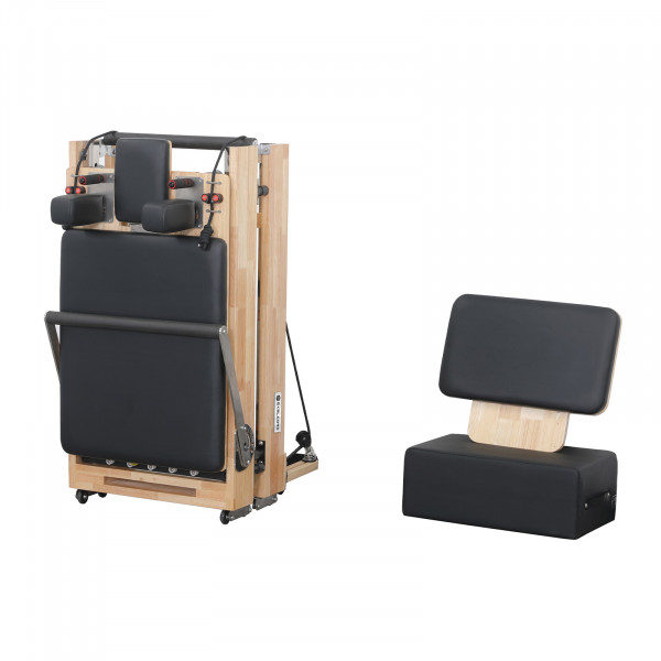 Angled view of the Skelcore Foldable Reformer - Oak folded with sitting box nearby