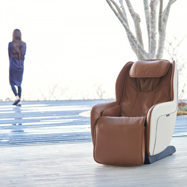 Beige Synca CirC+ Massage Chair indoors with user in background