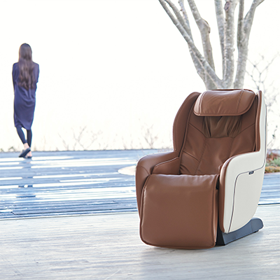 Beige Synca CirC+ Massage Chair indoors with user in background