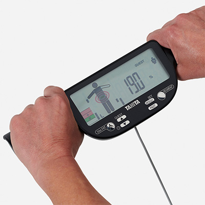 Model holding the TANITA BC-613 Segmental Body Composition Scale hand electrodes 