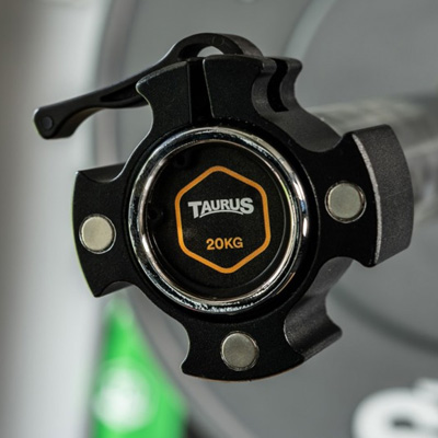A close-up of the Taurus Olympic Magnetic Collars mounted on a barbell.