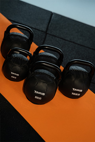 Set of Taurus Soft Kettlebells in different weights on an orange mat