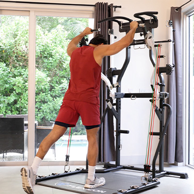 Image of the Taurus Flexicon in a home setting being used in a standing shoulder press.