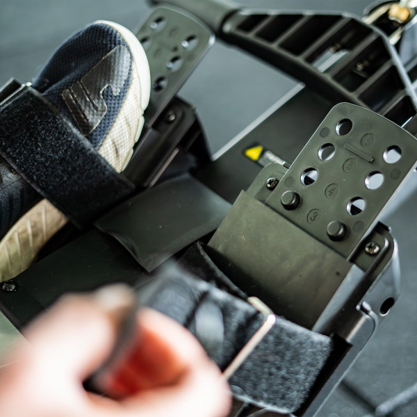 Close up of a user tightening the Taurus Elite Row foot strap
