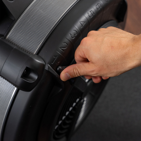 Model adjusting the resistance setting on the Taurus Elite Ski Trainer Pro