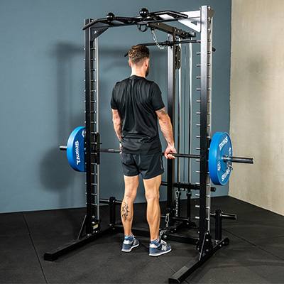 Person performing a barbell deadlift on the Taurus MS3 Pro Smith & Half Rack.