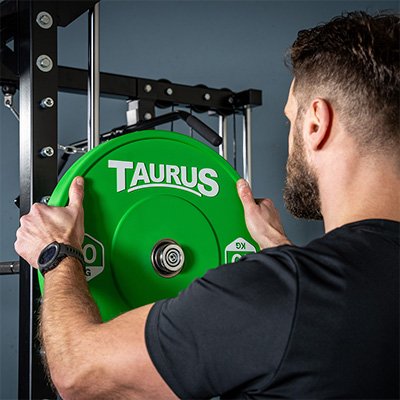 Close-up of weight plate being loaded onto the Taurus MS3 Pro Smith & Half Rack.