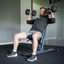An image of the Taurus Elite Adjustable Inc/Dec Bench with a model performing dumbbell shoulder press.