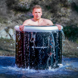 Lifestyle image of the Taurus Wellness Ice Bath - a model is lowering themselves into the ice bath