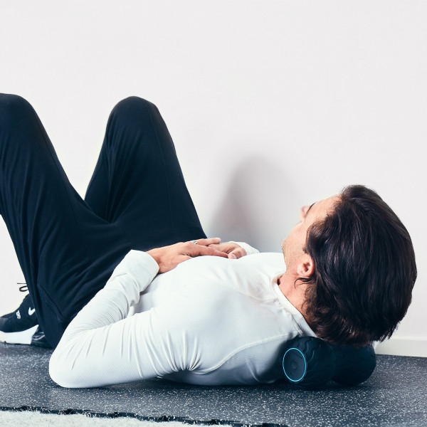 Relaxing on the Theragun Wave Duo for neck muscle relief.