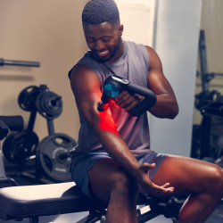 Lifestyle image of a model massaging their arm with the Theragun Pro Plus