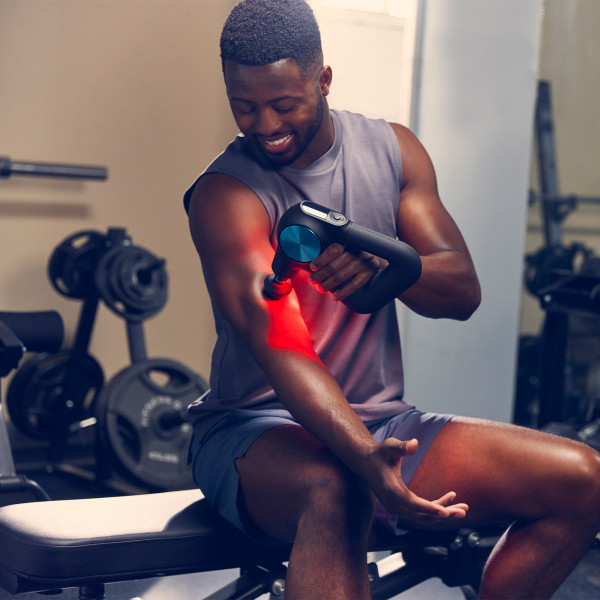 Lifestyle image of a model massaging their arm with the Theragun Pro Plus