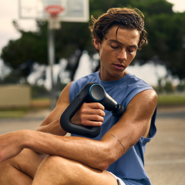 Lifestyle image of the Theragun Prime Plus being used by a model who is massaging their pectoral muscle