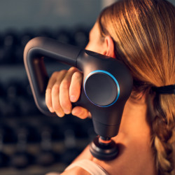 Lifestyle image of the Theragun Prime Plus being used by a model who is massaging their shoulder