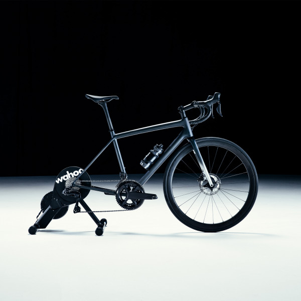 Wahoo KICKR CORE Smart Bike Trainer with a road bike mounted, side view.