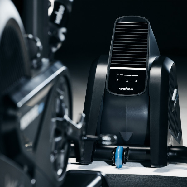 Close-up of the Wahoo KICKR HEADWIND next to a smart trainer.