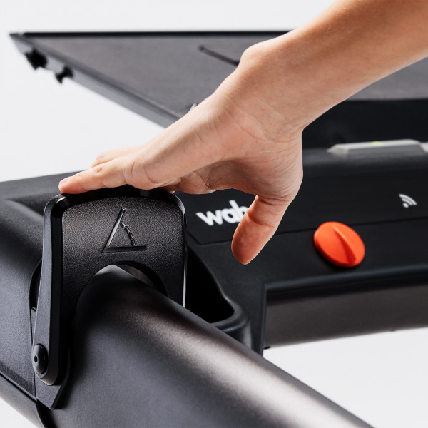 User adjusting incline paddle on Wahoo KICKR RUN Smart Treadmill