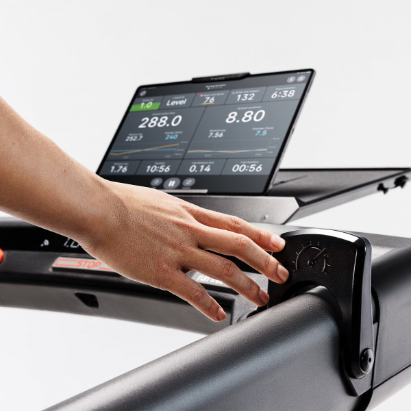 User adjusting speed paddle on Wahoo KICKR RUN Smart Treadmill