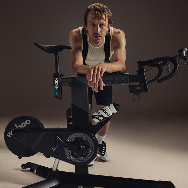 Model leaning on the Wahoo KICKR BIKE PRO