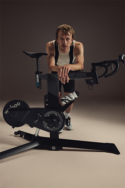 Model leaning on the Wahoo KICKR BIKE PRO