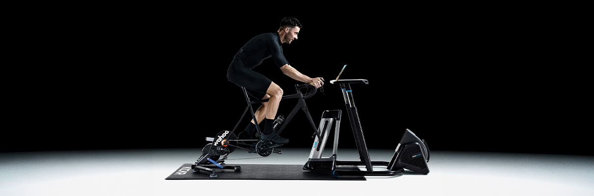 Model riding a bike on the Wahoo KICKR V6 Smart Trainer with Zwift Cog & Click in a complete indoor cycling setup