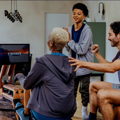 A group watching a person row using the WaterRower Ergatta Upgrade Set 