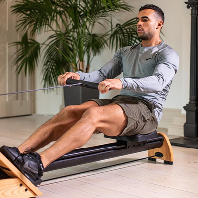Model using the WaterRower Hybrid Rowing Machine indoors 