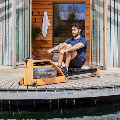 Model using the WaterRower Hybrid Rowing Machine outdoors 