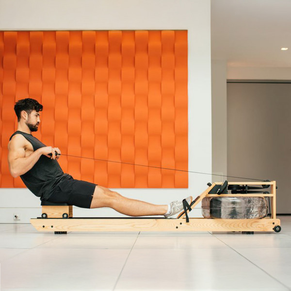 User rowing indoors on the WaterRower Pure VR3 Oak Rowing Machine